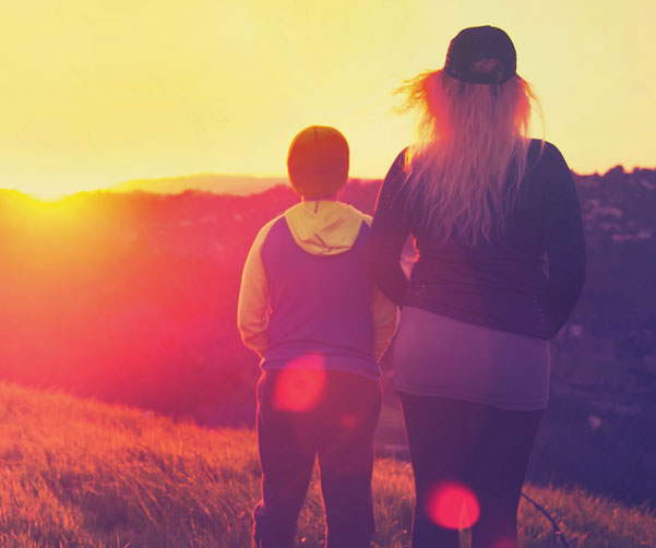 image of two members of a family affected by cancer looking into the sunset.