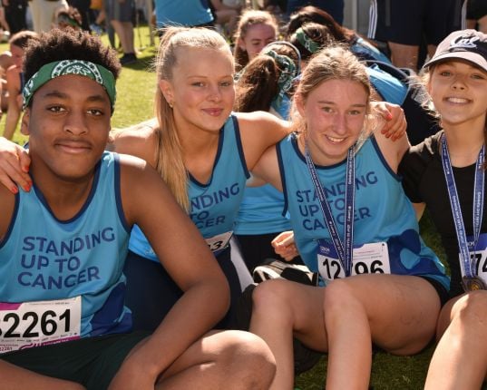 A group of young Canteen fundraisers at a running challenge event wearing Canteen bandannas and t shirts