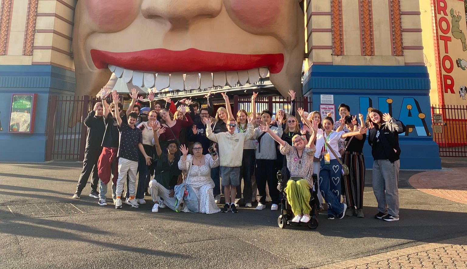 A group of Canteen young people posing outside Luna Park Melbourne