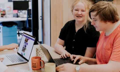 A young girl and young boy working on laptops at a table